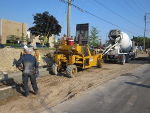 Concrete mixer truck feeding a curb machine