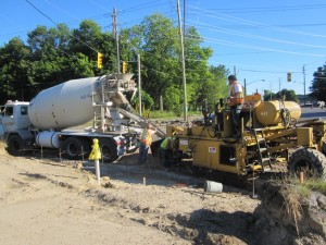 Concrete mixer truck feeding a curb machine on a granular base