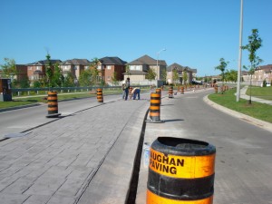 Completed stamped-concrete streetscape with a Vaughan Paving traffic barrel in the foreground