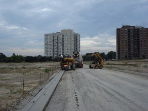 New subdivision roadway under construction with a curb machine at work